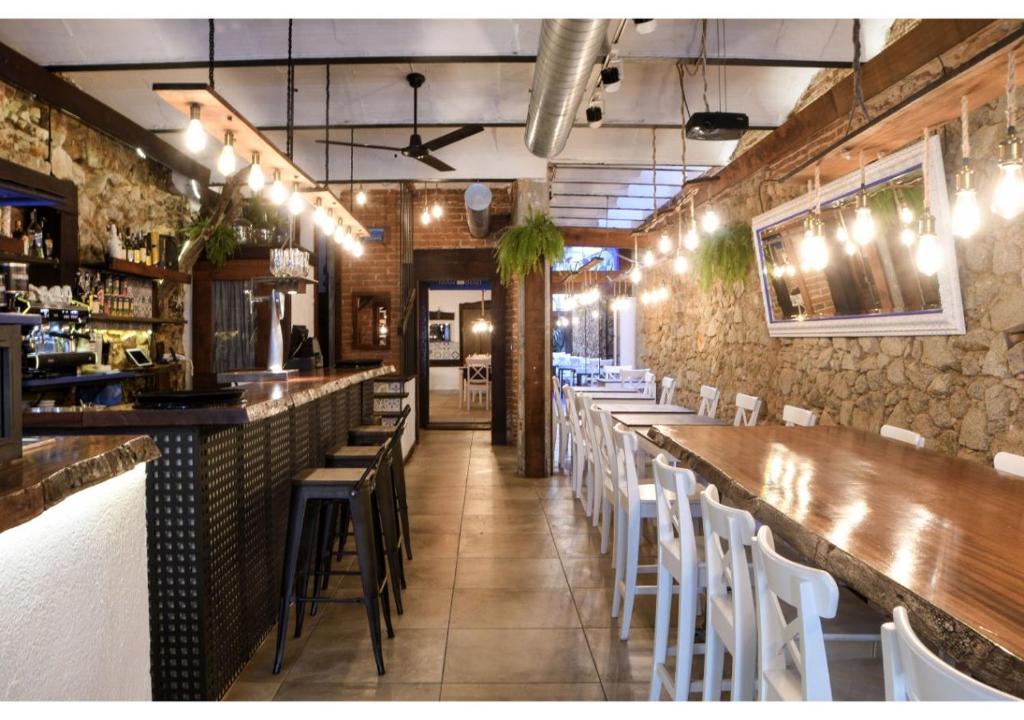 un restaurante con un bar con sillas blancas en L'Hostalet de Canet, en Canet de Mar