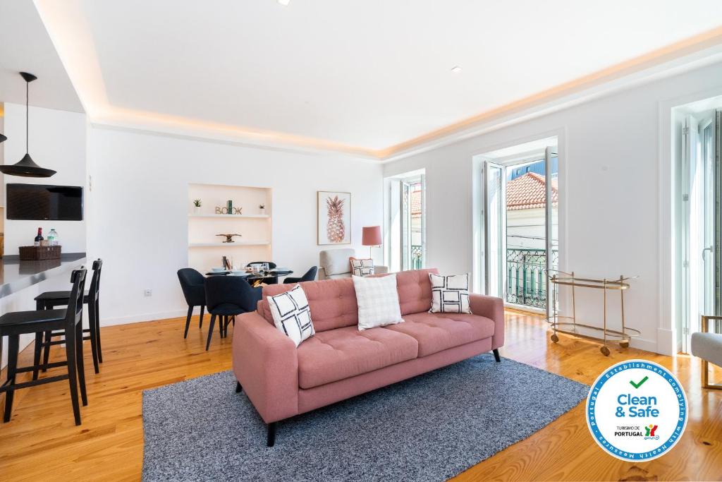 sala de estar con sofá rosa y comedor en LXLUXHOME - Combro Luxury Apartment, en Lisboa