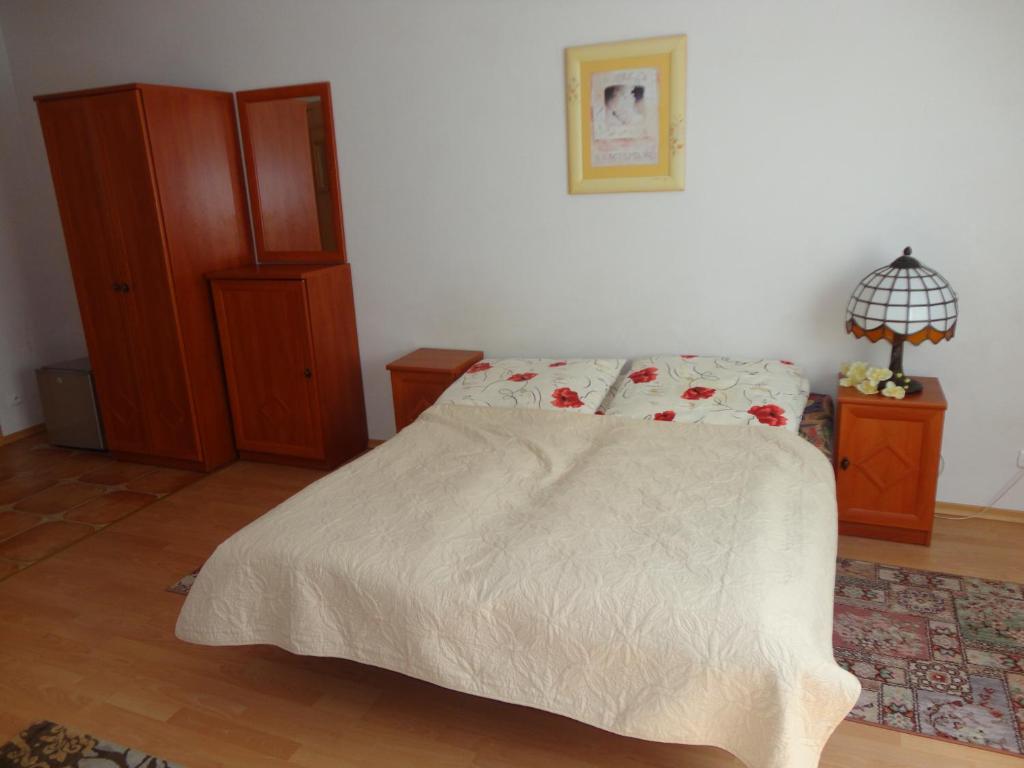 a bedroom with a bed with a white comforter at Pensjonat Aida in Kołobrzeg