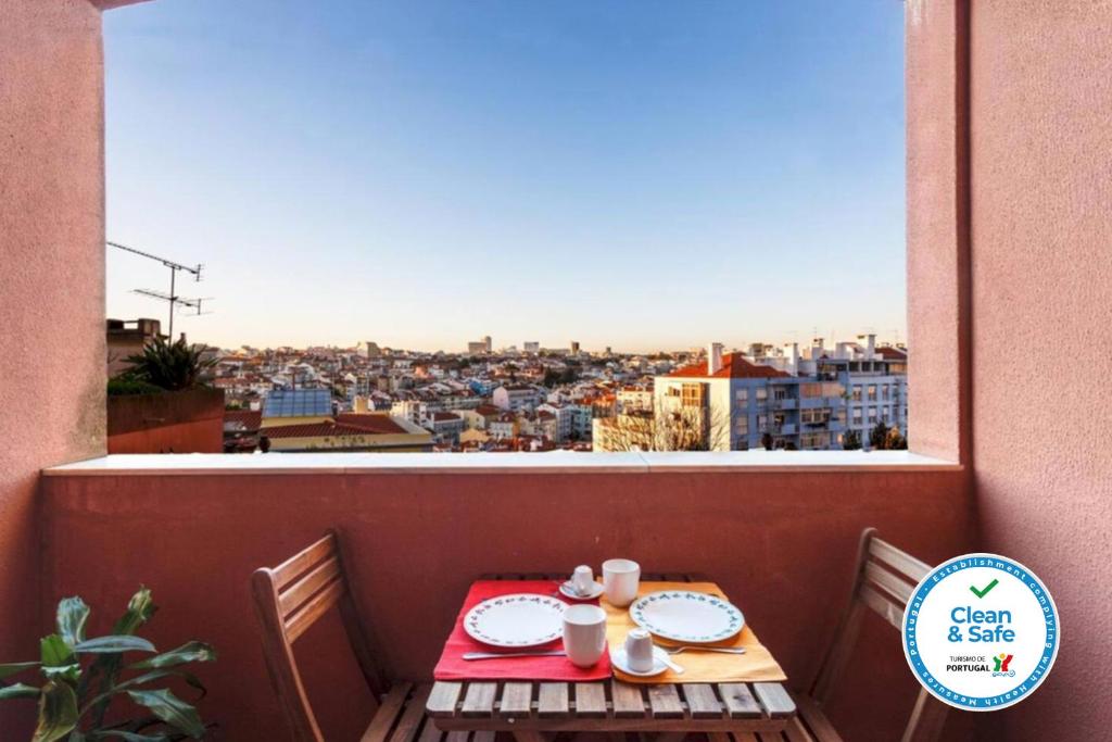 a table on a balcony with a view of a city at WHome | Damasceno Large Apartment #39 in Lisbon