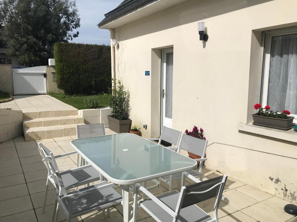 einen Glastisch und Stühle auf einer Terrasse in der Unterkunft Gîte la Briantaise in Saint-Malo