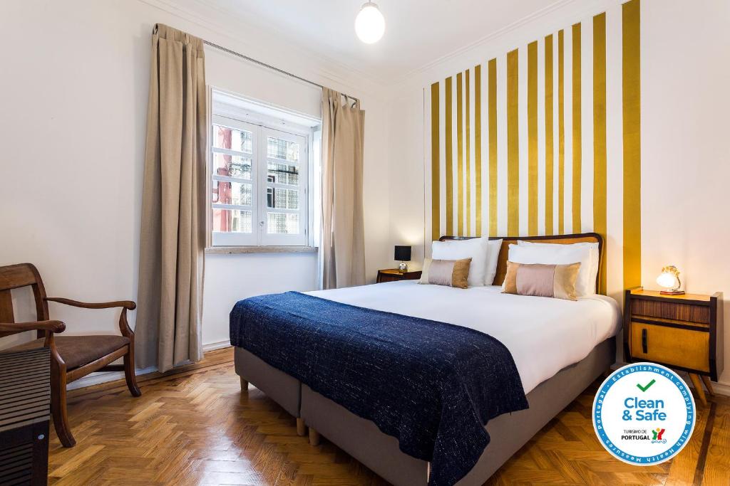 una camera con un letto e una sedia e una finestra di WHome | Damasceno Contemporary Apartment #59 a Lisbona