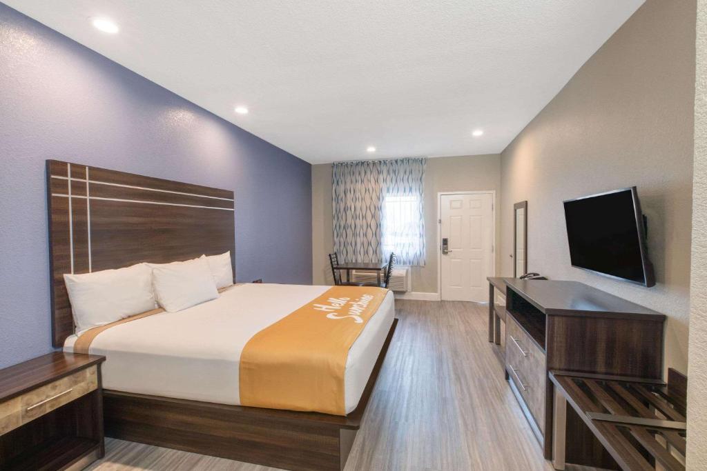 een hotelkamer met een bed en een flatscreen-tv bij Days Inn & Suites by Wyndham La Porte in La Porte