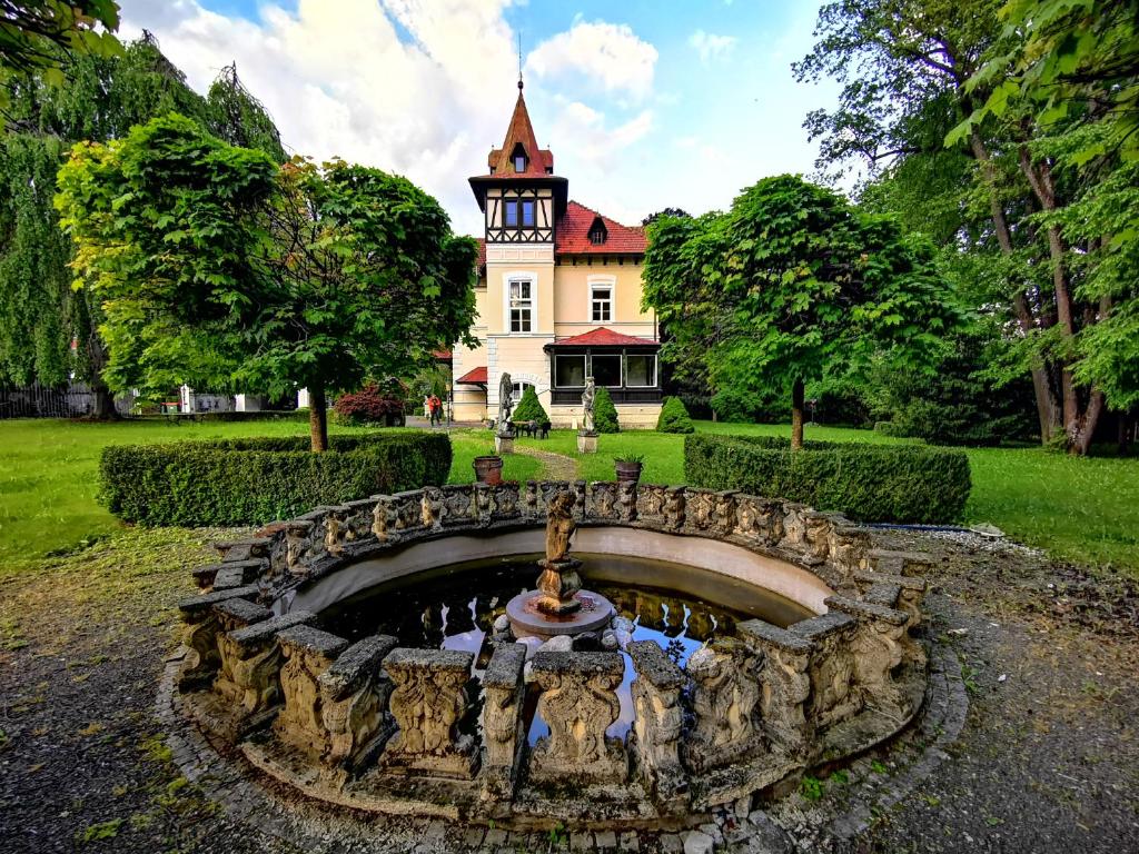 a house with a fountain in front of a yard at Glögglhof in Trofaiach