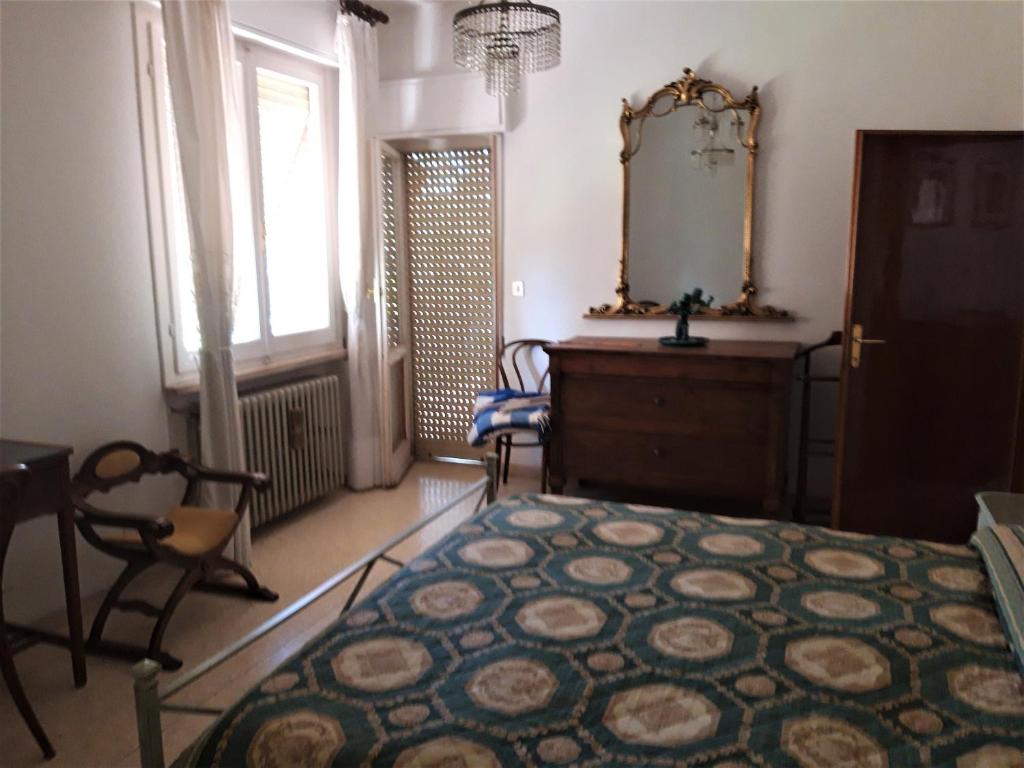 een slaapkamer met een bed, een ladekast en een spiegel bij Da Franca in Assisi