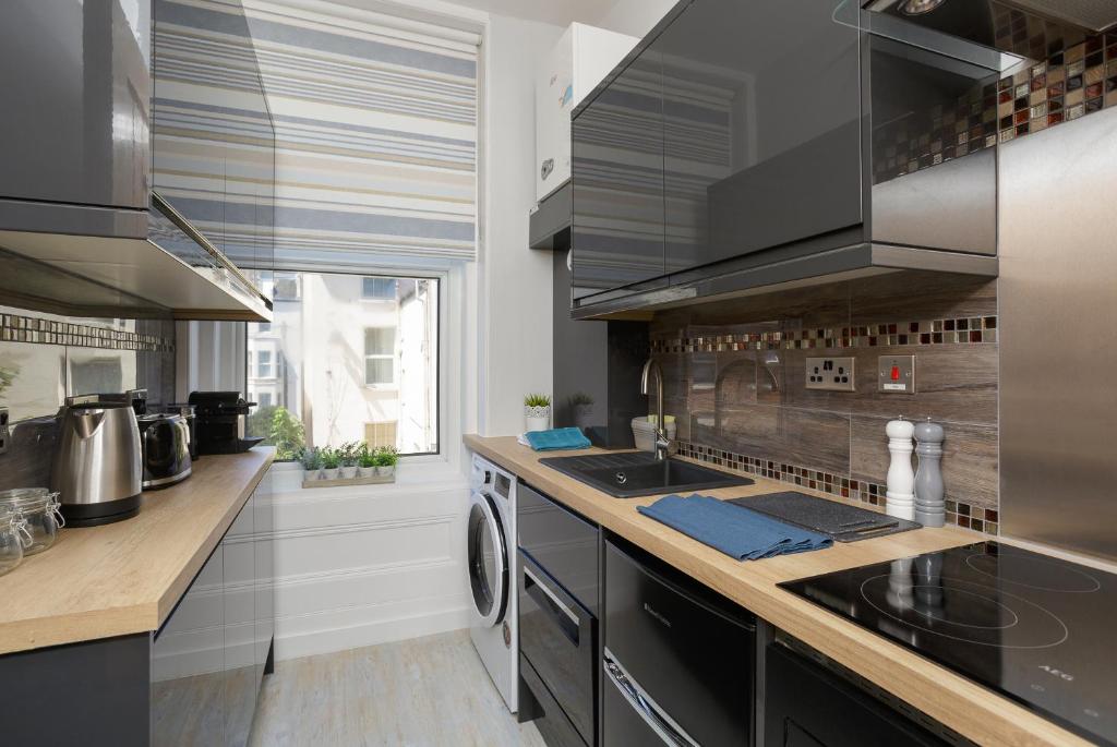 a kitchen with a sink and a stove top oven at Stopover at SEABIRD APARTMENTS central Southsea in Portsmouth