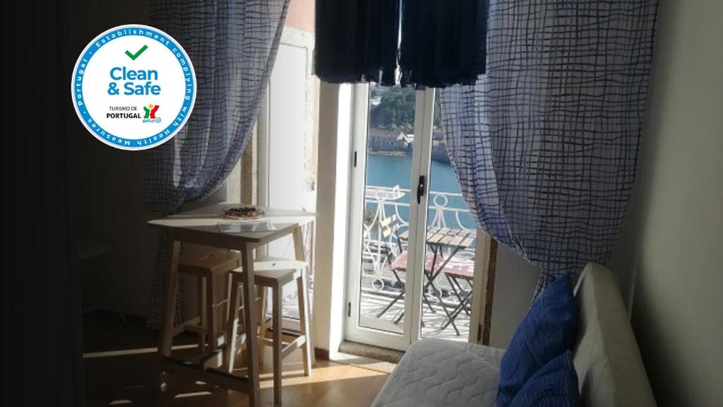 Schlafzimmer mit Glasschiebetür, Tisch und Balkon in der Unterkunft Oportobestview-Sun in Porto