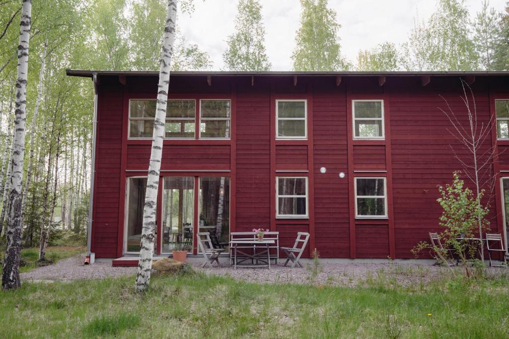 una casa roja con una mesa de picnic delante de ella en STF Tåtorp Cafe & Logi Göta Kanal, en Tåtorp