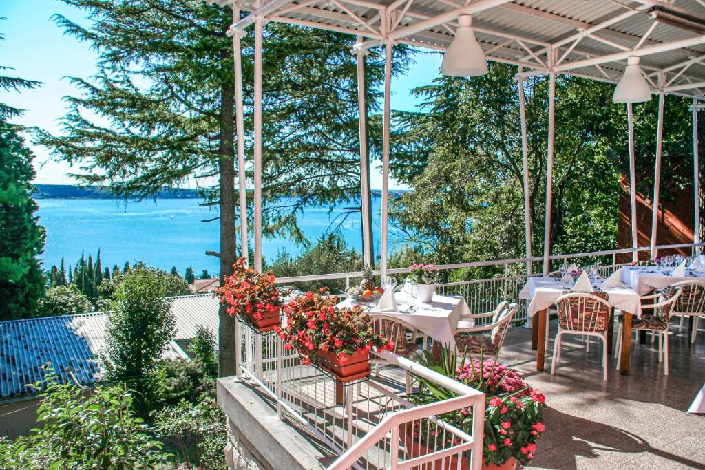 a restaurant with tables and flowers on a balcony at Maestral Residence in Portorož