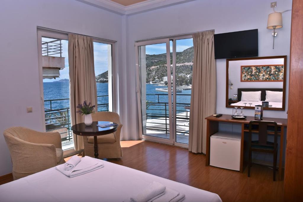 a hotel room with a bed and a desk with a view of the ocean at Grand Hotel Loutraki in Loutraki