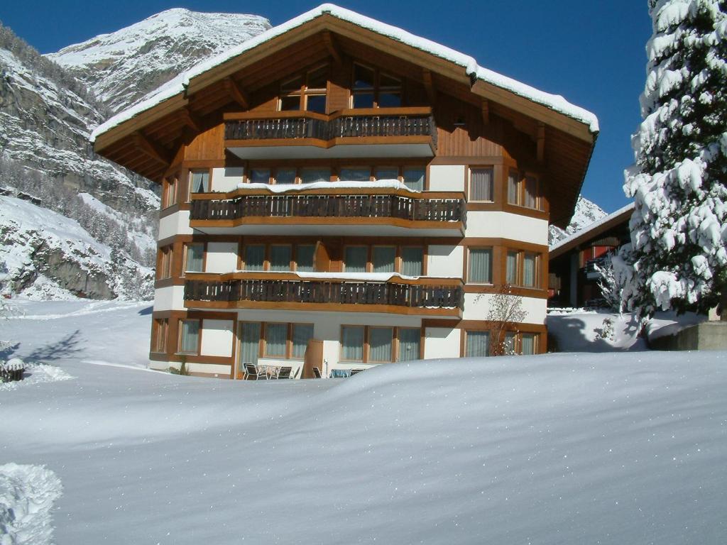 a building in the snow in front of a mountain at Haus Pan in Zermatt