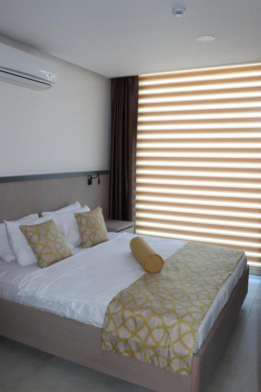 a bedroom with a large bed with a large window at Zest Exclusive Hotel & Spa in Ortakent