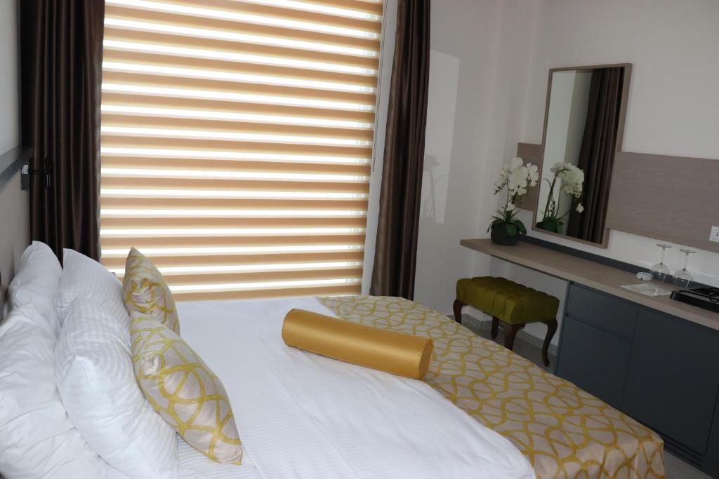 a bedroom with a bed and a desk and a mirror at Zest Exclusive Hotel & Spa in Ortakent