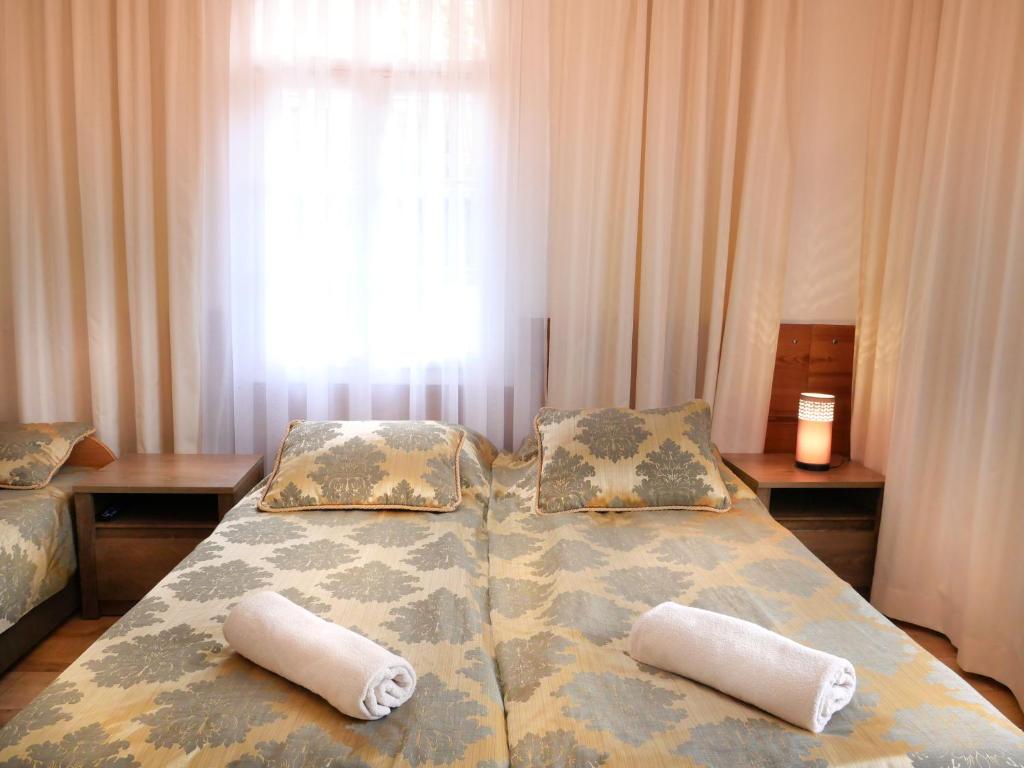 a bedroom with two beds with pillows and a window at Pokoje Szczawnica Centrum - duży ogród in Szczawnica