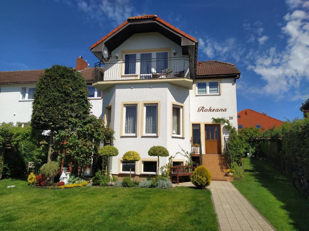 Großes weißes Haus mit Balkon in der Unterkunft Dom Gościnny Roksana in Rewal