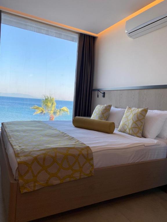 a bedroom with a large bed with a large window at Zest Exclusive Hotel & Spa in Ortakent