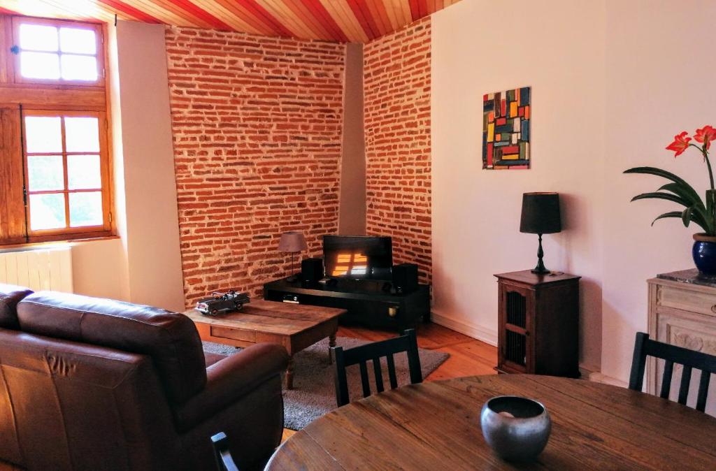ein Wohnzimmer mit einem Sofa und einem Tisch in der Unterkunft Gîte bord du Tarn in Gaillac
