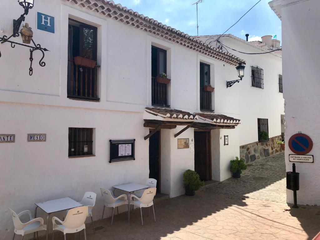 un edificio con mesas y sillas en un patio en Hotel Posada del Bandolero, en Borge