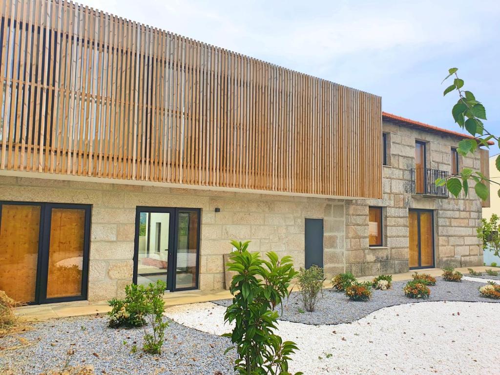 a stone house with a wooden facade at Casa das Hortênsias in Alijó