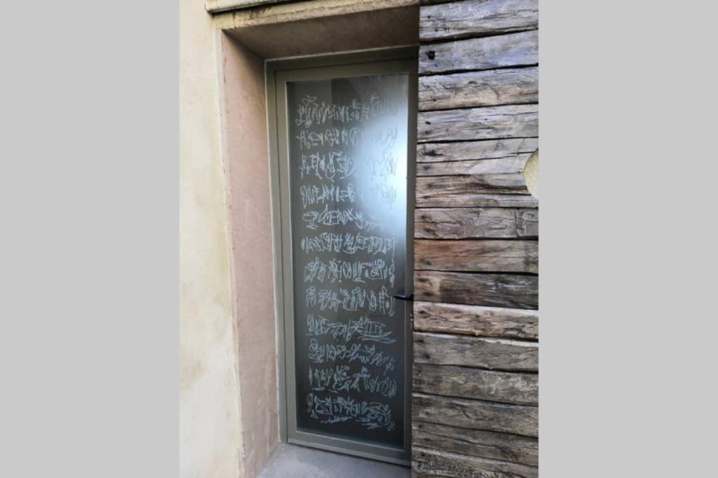 una finestra con scrittura sul lato di un edificio di Atelier di Carlo a Monticiano