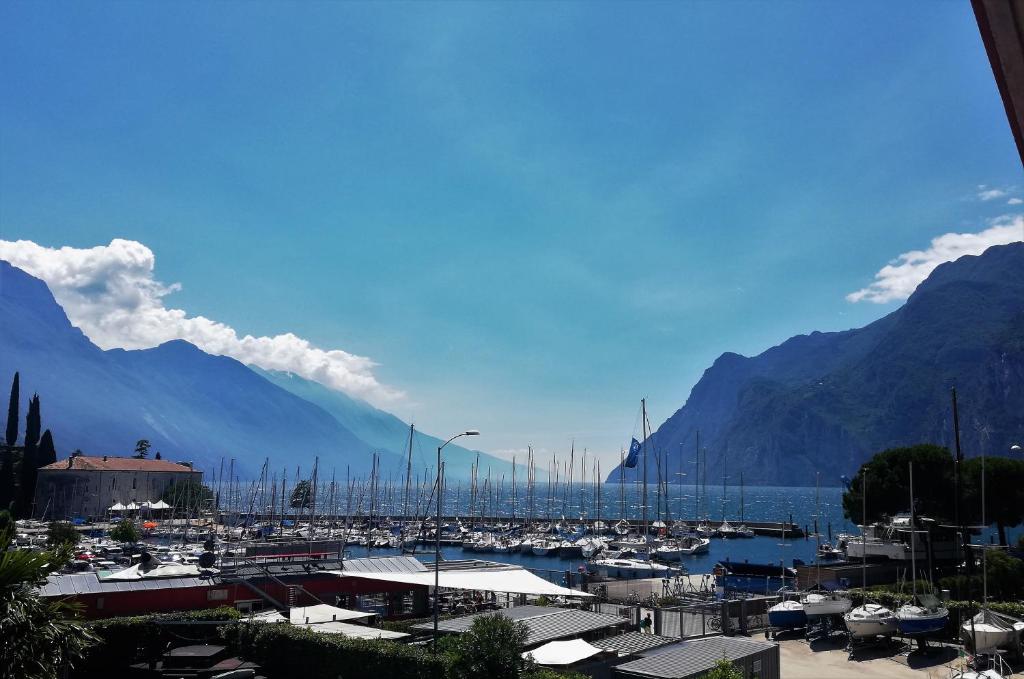 Une bande de bateaux amarrés dans un port avec des montagnes dans l'établissement Residence Cristine, à Riva del Garda