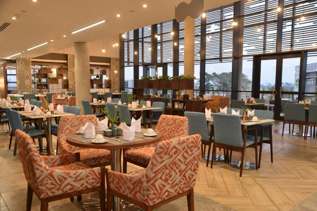 a restaurant with tables and chairs and windows at Town Lodge Umhlanga in Durban