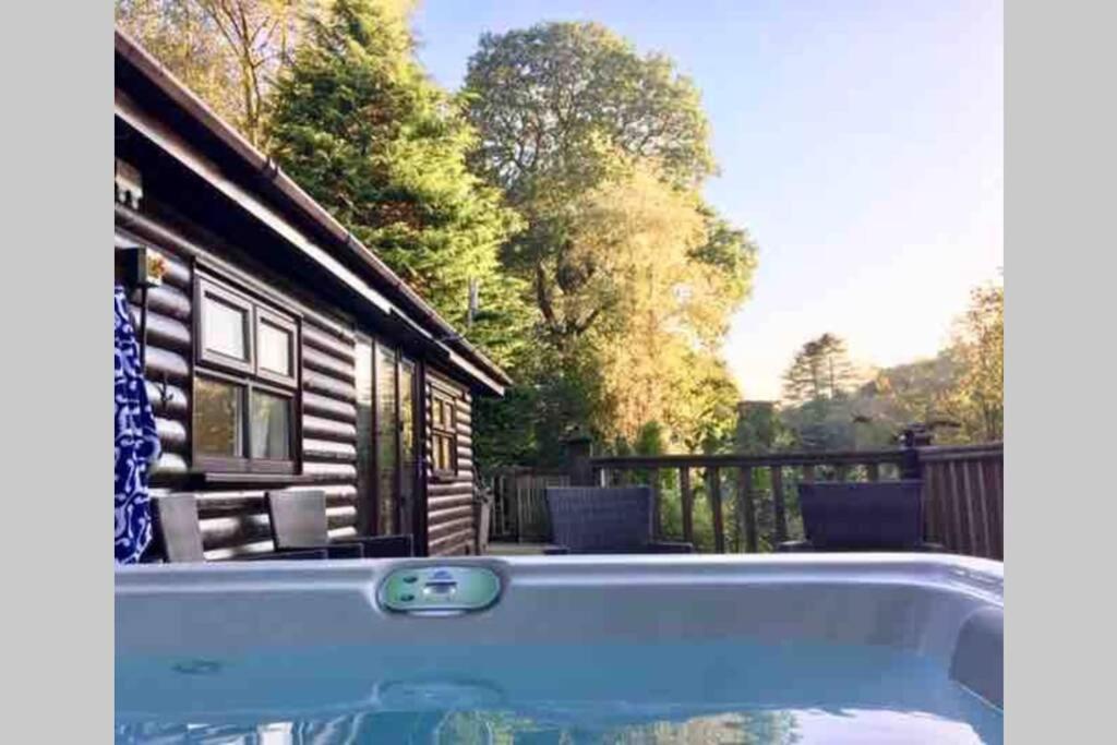 una piscina frente a una cabaña de madera en Mistletoe One Luxury Lodge with Hot Tub Windermere, en Windermere