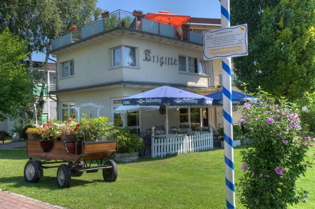 una casa con flores en una carreta delante de ella en Hotel Brigitte en Bad Krozingen