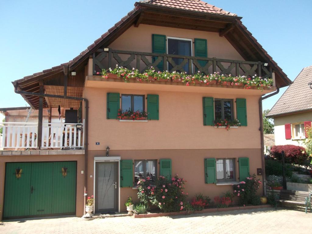 a house with green shutters and a balcony at Gite les Rosiers in Traubach-le-Bas