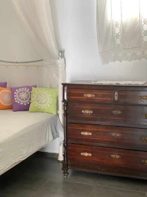 a bedroom with a dresser next to a bed at Chora Anargyros in Ios Chora
