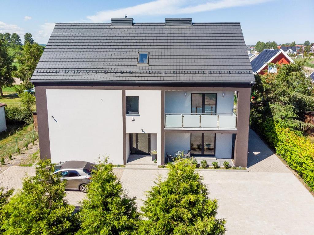 a house with a car parked in front of it at Verde House in Karwia