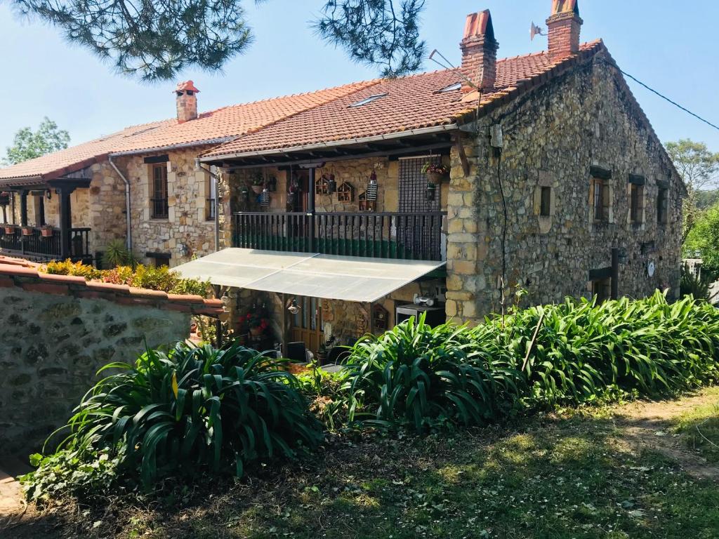 Casa de piedra antigua con porche y balcón en Posada La Herradura, en Liermo