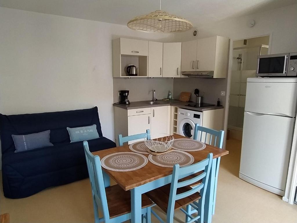 a kitchen and dining room with a table and chairs at Logement 106 2-4 Personnes 500 m plage classé 2 Etoiles in Dolus d'Oléron