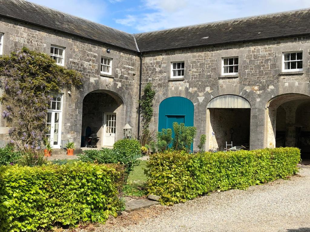 un edificio con una puerta azul y algunos arbustos en Townley Hall Apartments, en Slane