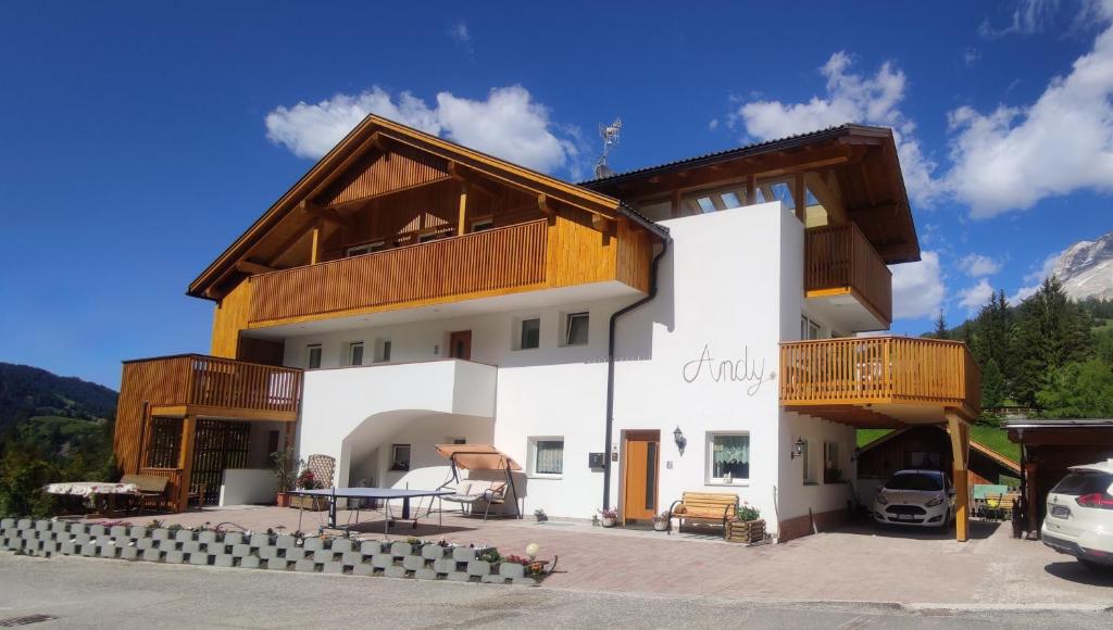 een groot wit gebouw met houten balkons bij Ciasa Andy in Badia