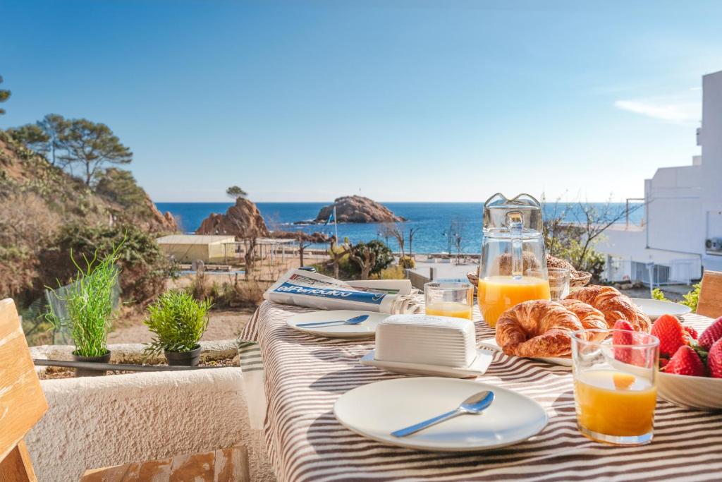 a table with food and a view of the ocean at Lets Holidays garden house in front of the beach in Tossa de Mar