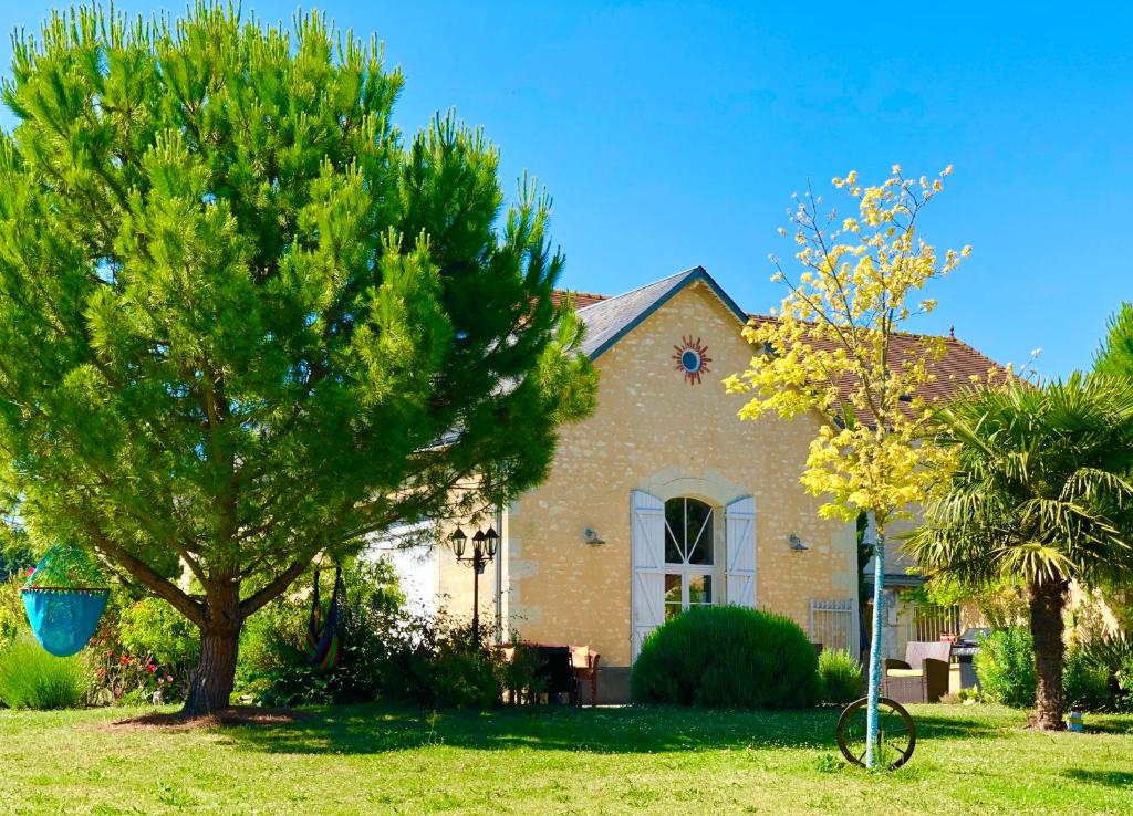 una casa con un árbol delante de ella en Ecole de Mathuna de Marigny Brizay, en Marigny-Brizay