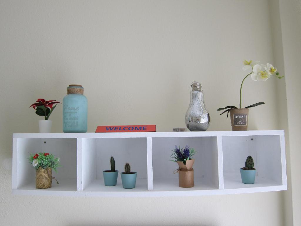 a white shelf with potted plants on it at BONITO APARTAMENTO TRIANA-LOS REMEDIOS in Seville