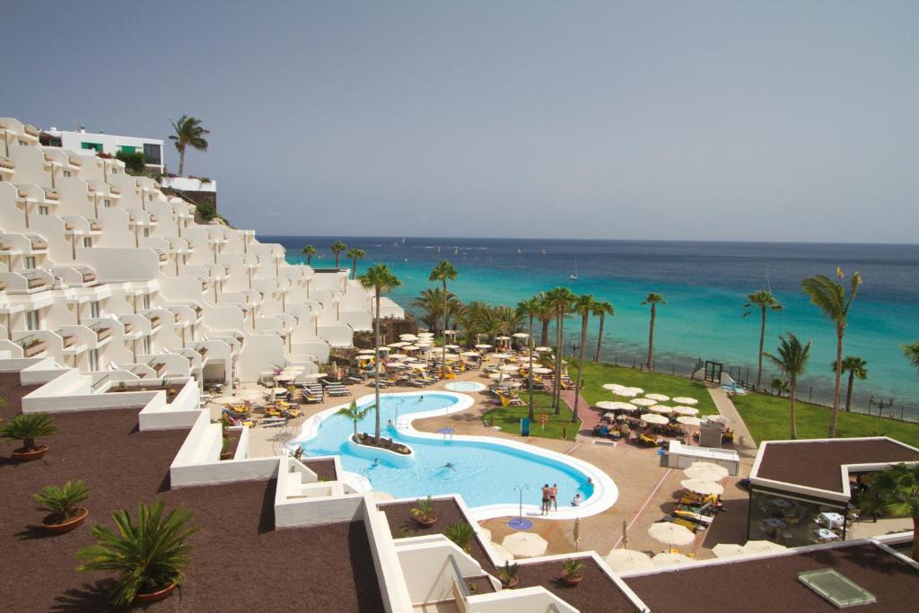 een luchtzicht op een resort met een zwembad en de oceaan bij Hotel Riu Calypso - Adults Only in Playa Jandia