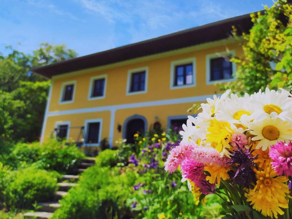 ein gelbes Haus mit Blumen davor in der Unterkunft Naturoase Mühlviertel in Sankt Johann am Wimberg