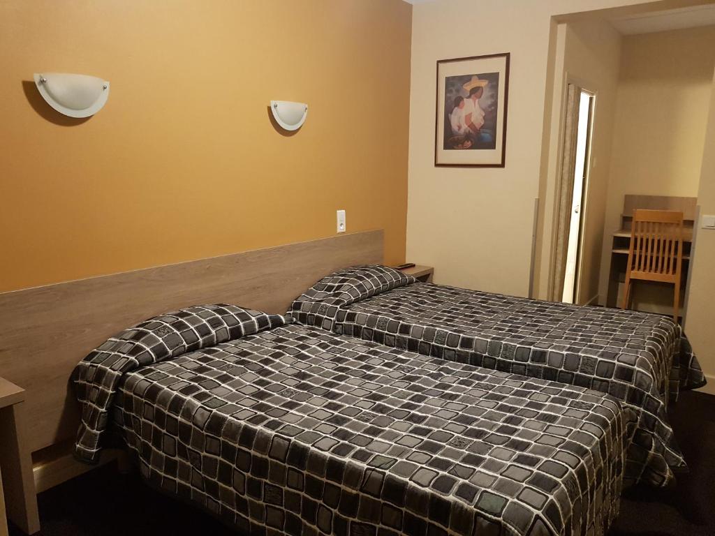 Postel nebo postele na pokoji v ubytování Hôtel Saint Sébastien