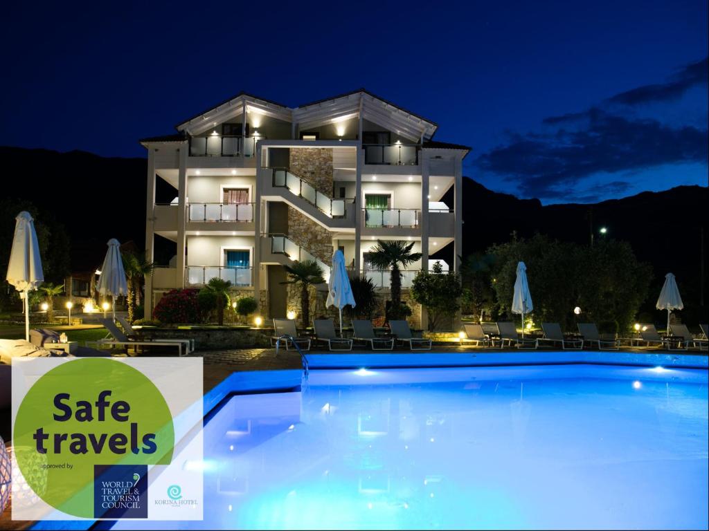 a villa with a swimming pool at night at Korina Hotel in Skala Potamias