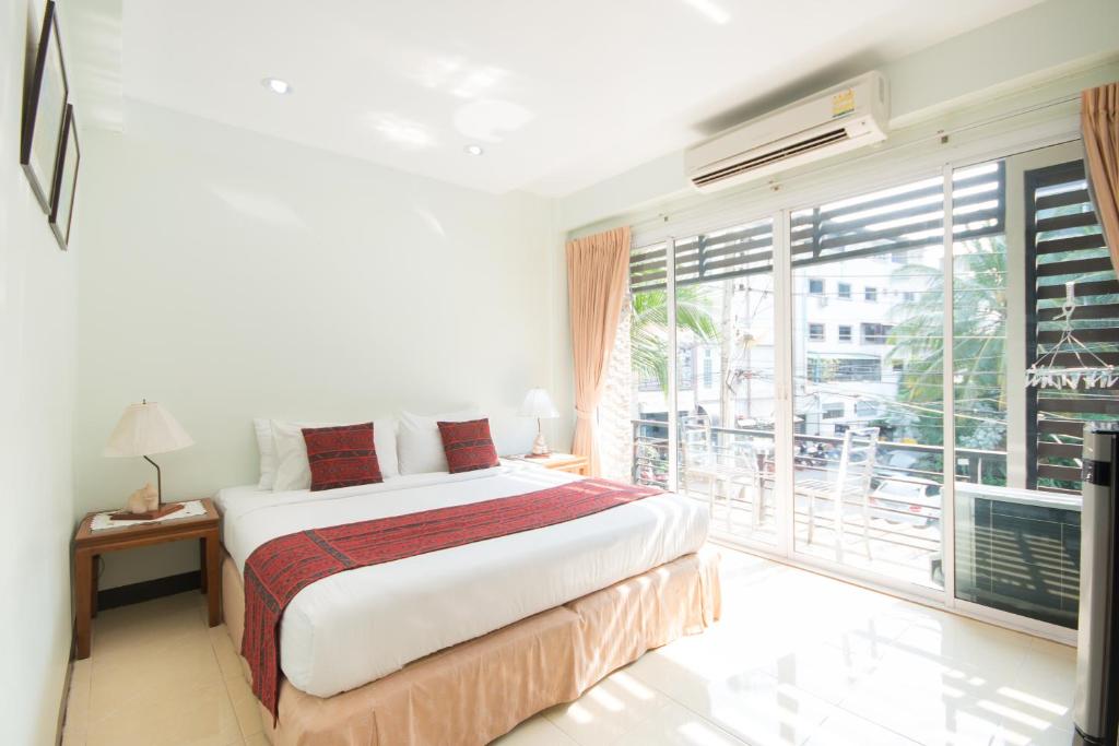 a bedroom with a bed and a large window at Admire House in Pattaya
