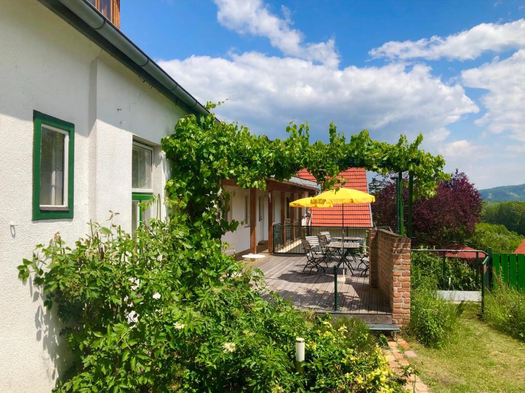 uma casa com um pátio com um guarda-chuva amarelo em Sonnhof Ressl em Klosterneuburg
