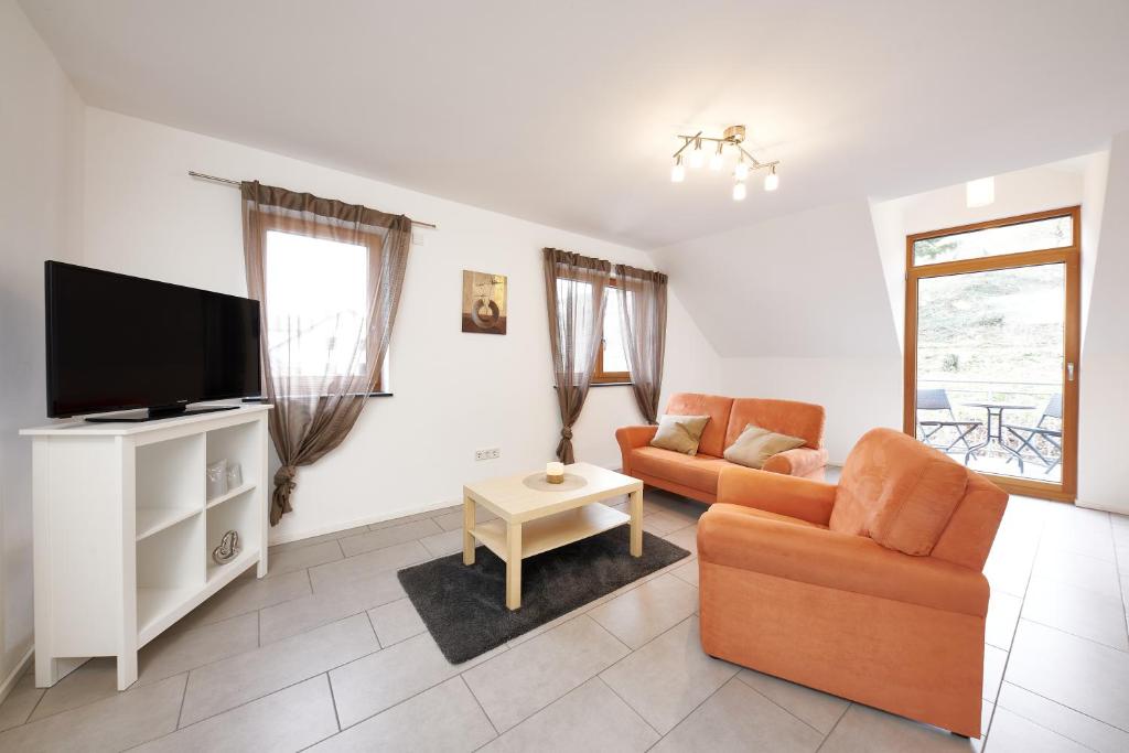 ein Wohnzimmer mit einem Sofa und einem TV in der Unterkunft Ferienwohnung Weißburgunder in Lieser
