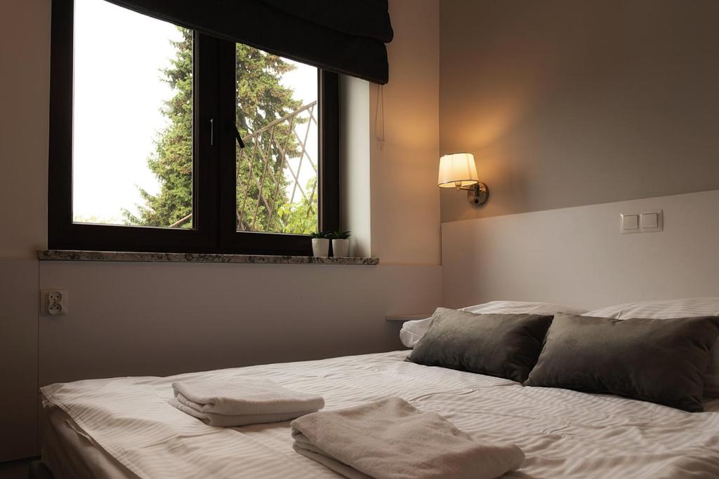 ein Schlafzimmer mit einem Bett mit zwei Handtüchern darauf in der Unterkunft Bon Ton in Stettin