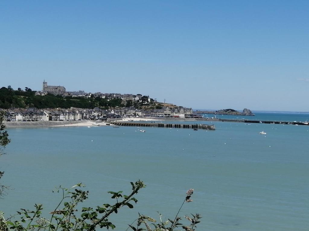 una gran masa de agua con una playa y un muelle en Gîte "L'Escapade Marine", en Cancale