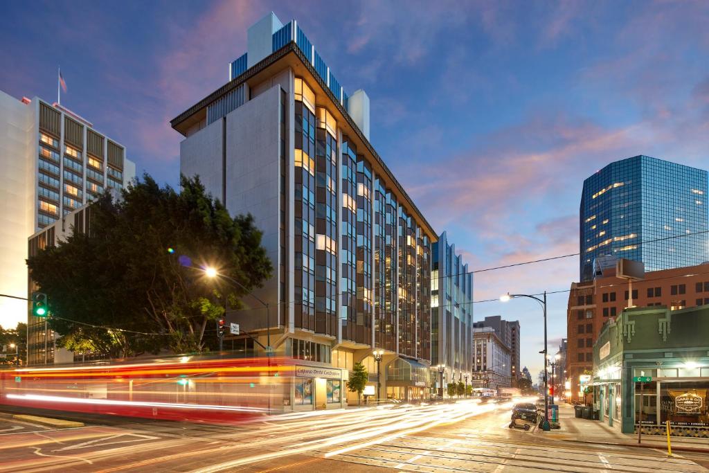 a city street with a tall building and traffic at The Bristol Hotel San Diego in San Diego