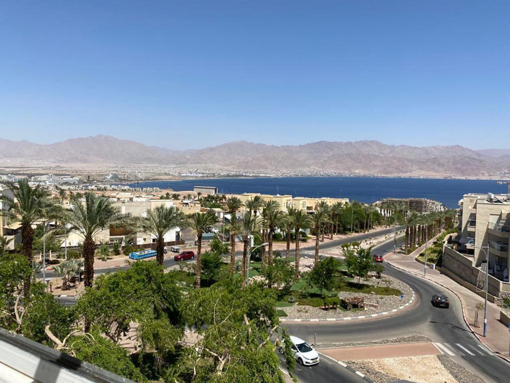 een stad met een weg, palmbomen en het water bij Appartement à Eilat vue mer in Eilat