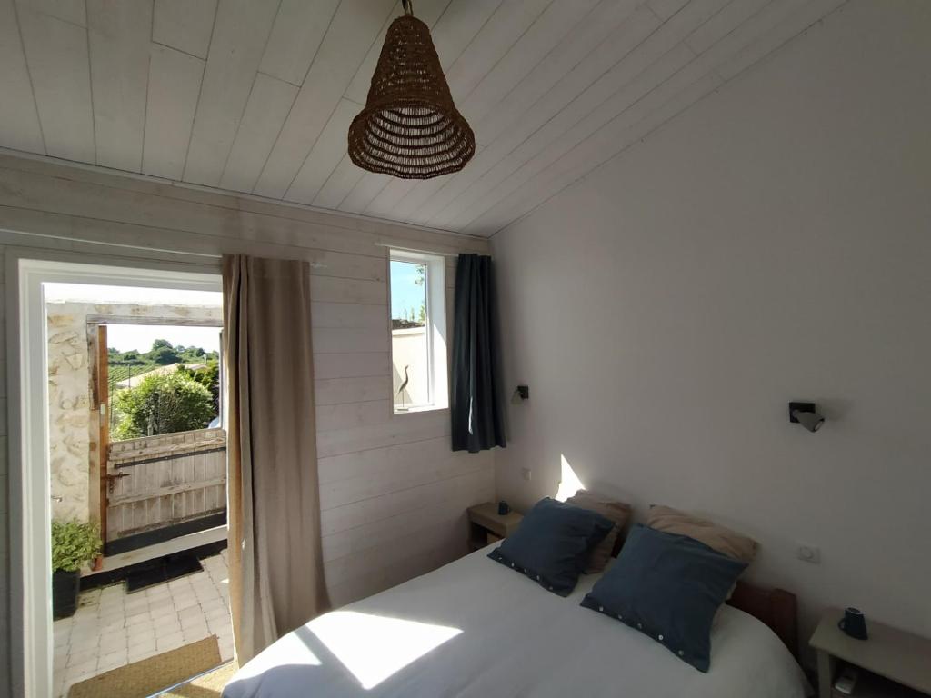 een slaapkamer met een bed met blauwe kussens en een raam bij La SUITE des AUGUSTINS in Baurech